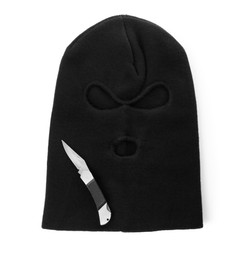 Photo of Black knitted balaclava and knife on white background, top view
