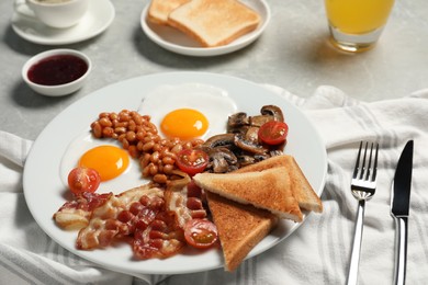 Photo of Traditional English breakfast served on grey table, closeup