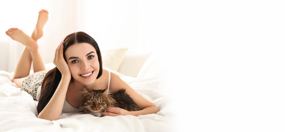 Young woman with her cute pet on bed at home, space for text. Banner design