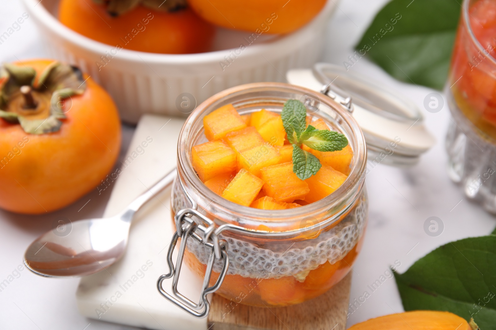 Photo of Delicious dessert with persimmon and chia seeds on table