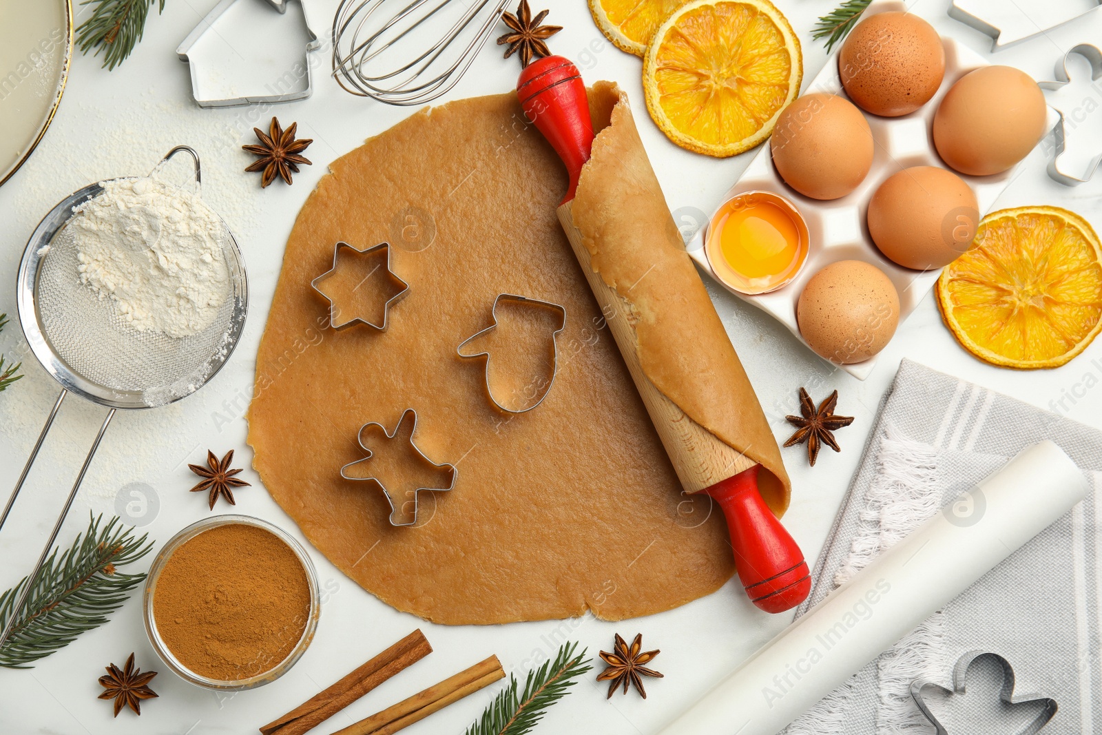 Photo of Flat lay composition with dough and cookie cutters on white table. Christmas biscuits