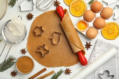 Flat lay composition with dough and cookie cutters on white table. Christmas biscuits