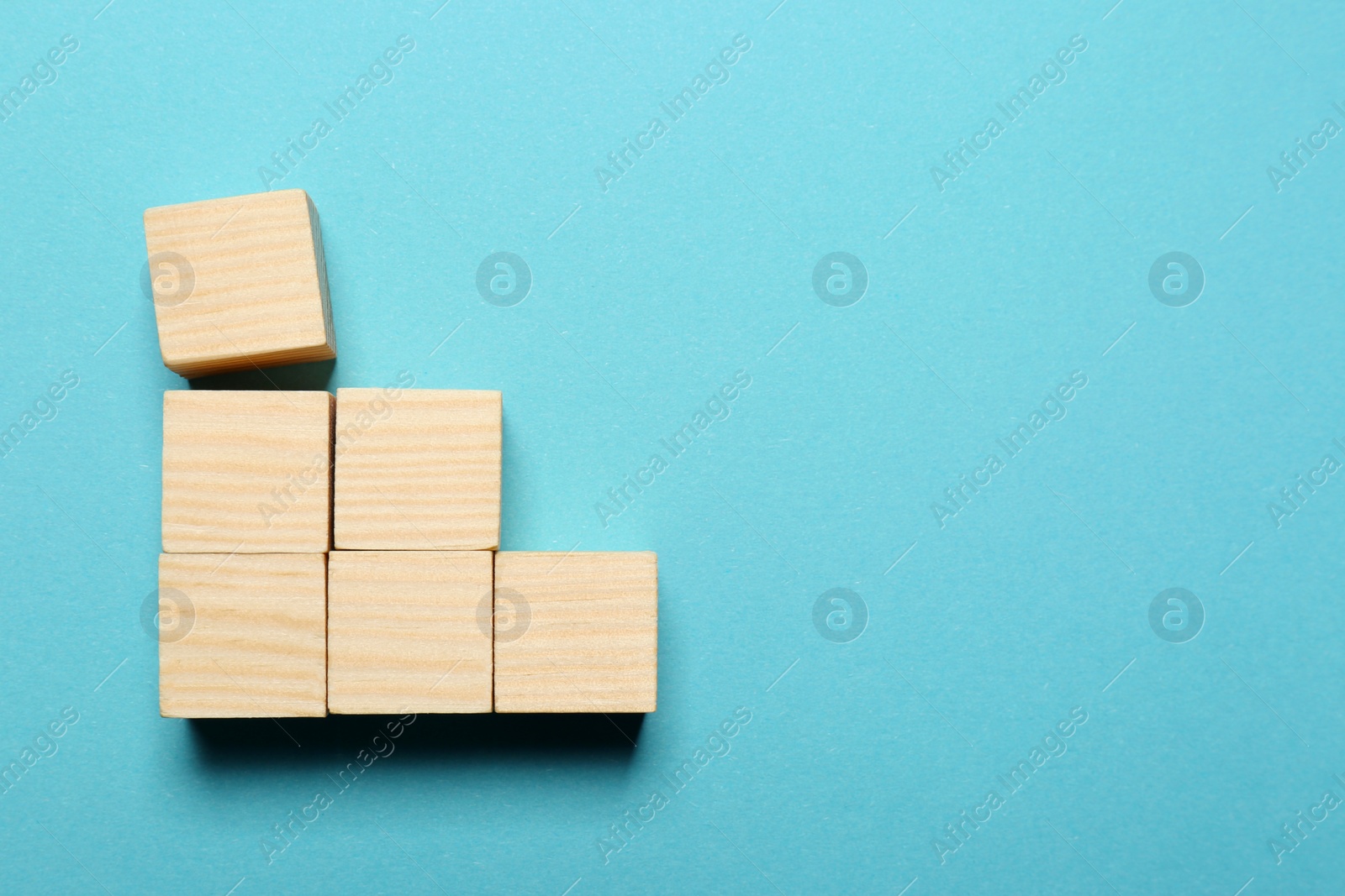 Photo of Blank cubes on light blue background, flat lay with space for text. Idea concept