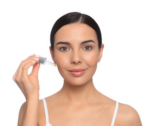 Photo of Young woman with dropper of essential oil on white background