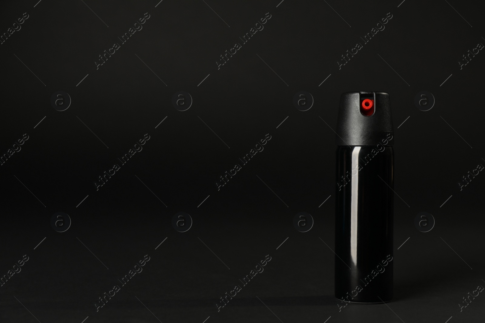 Photo of Bottle of gas pepper spray on black background. Space for text