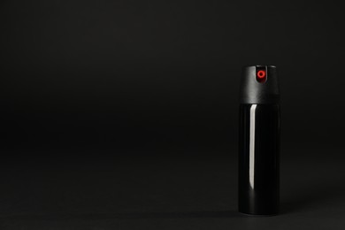 Bottle of gas pepper spray on black background. Space for text