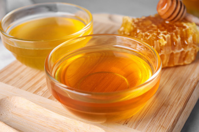 Tasty organic honey on table with board, closeup