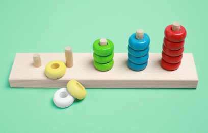 Photo of Stacking and counting game wooden pieces on green background. Educational toy for motor skills development