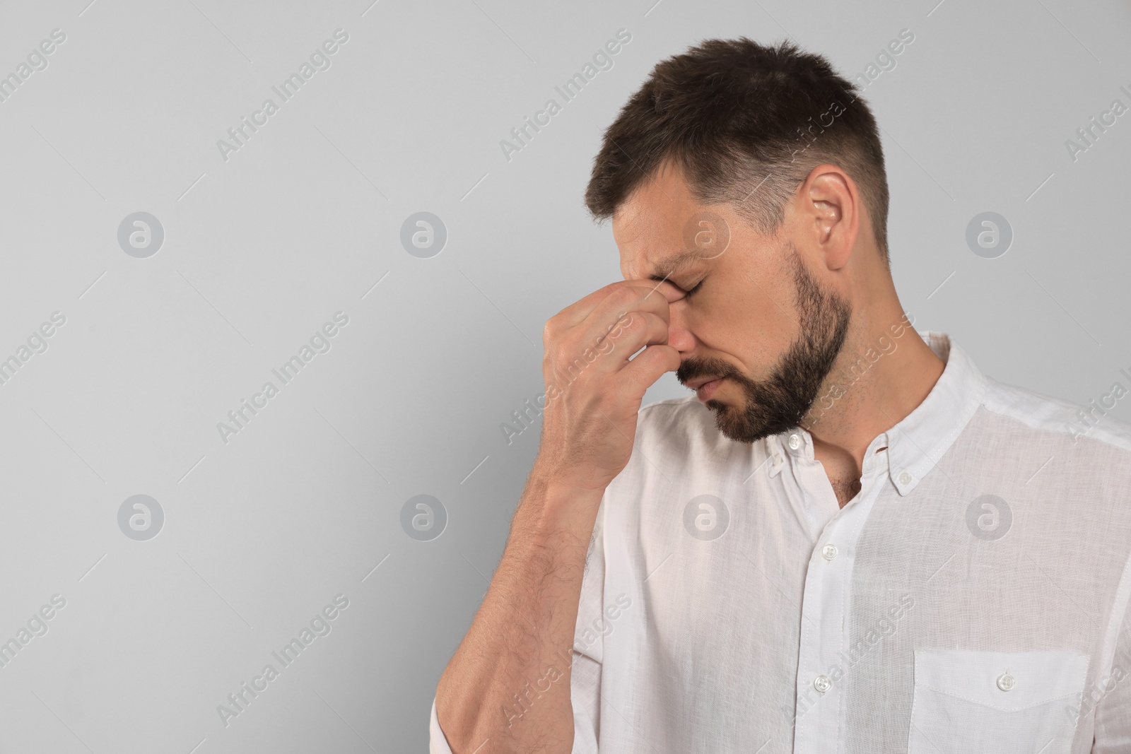 Photo of Man suffering from eyestrain on light background, space for text