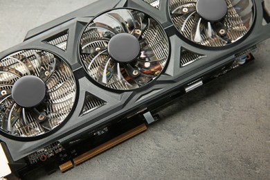 Photo of One computer graphics card on grey textured table, above view