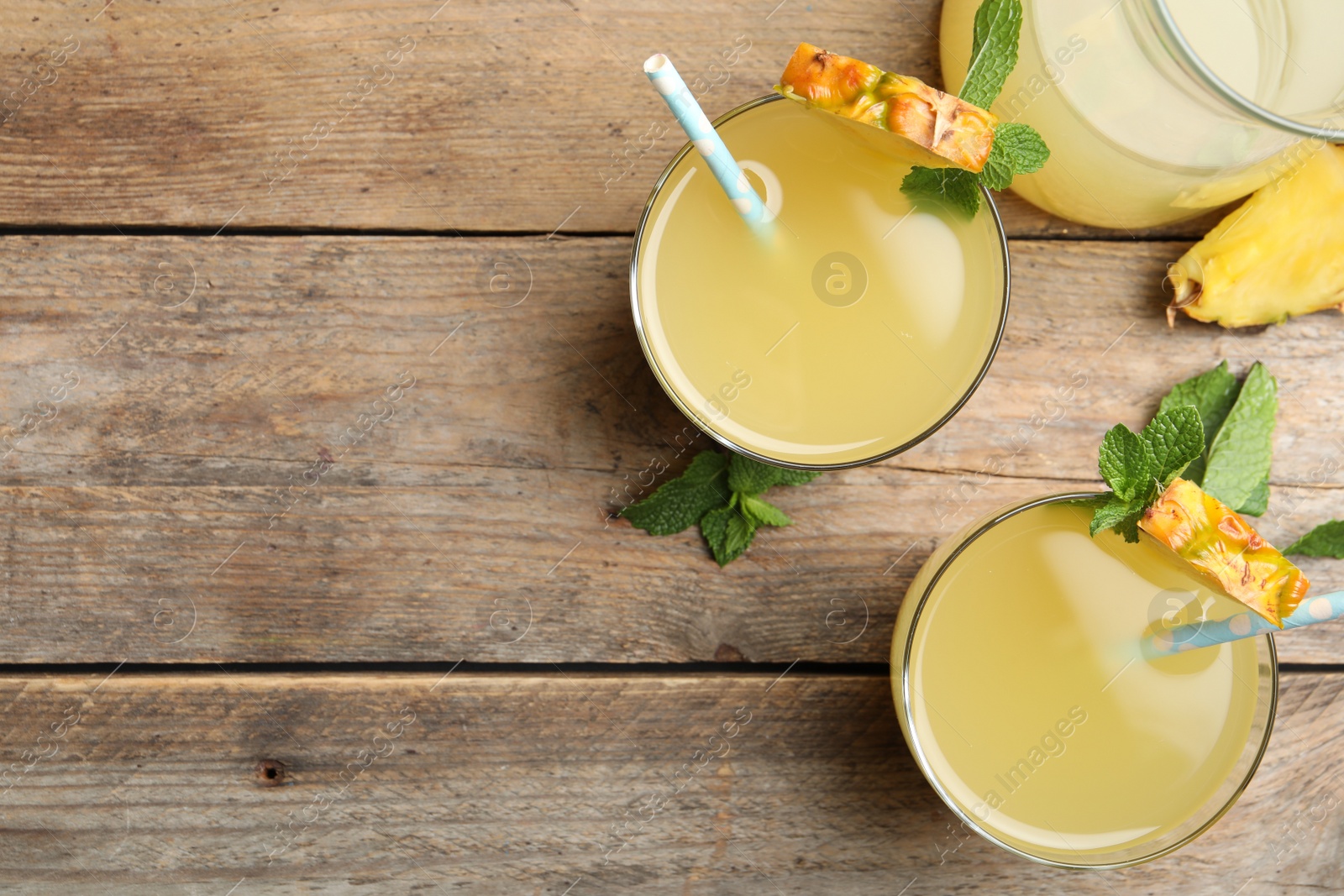 Photo of Delicious fresh pineapple juice with mint on wooden table, flat lay. Space for text