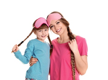 Happy woman and daughter in pajamas on white background