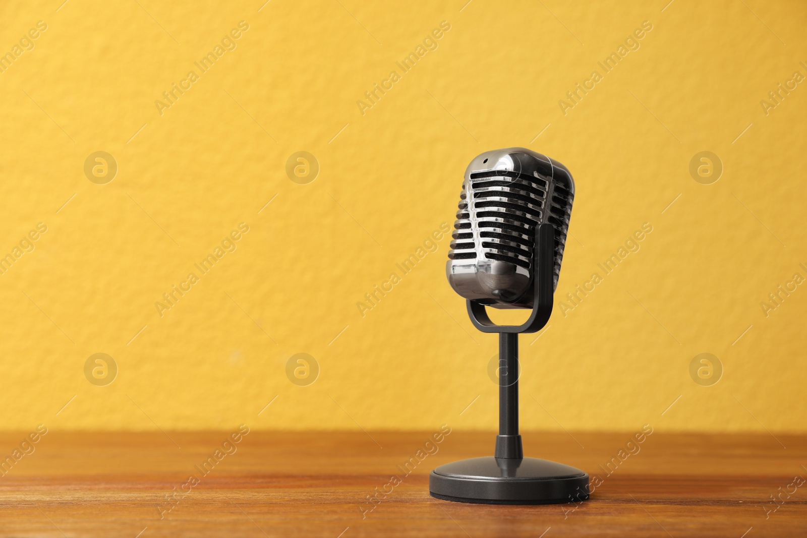 Photo of Vintage microphone on wooden table, space for text. Journalist's equipment