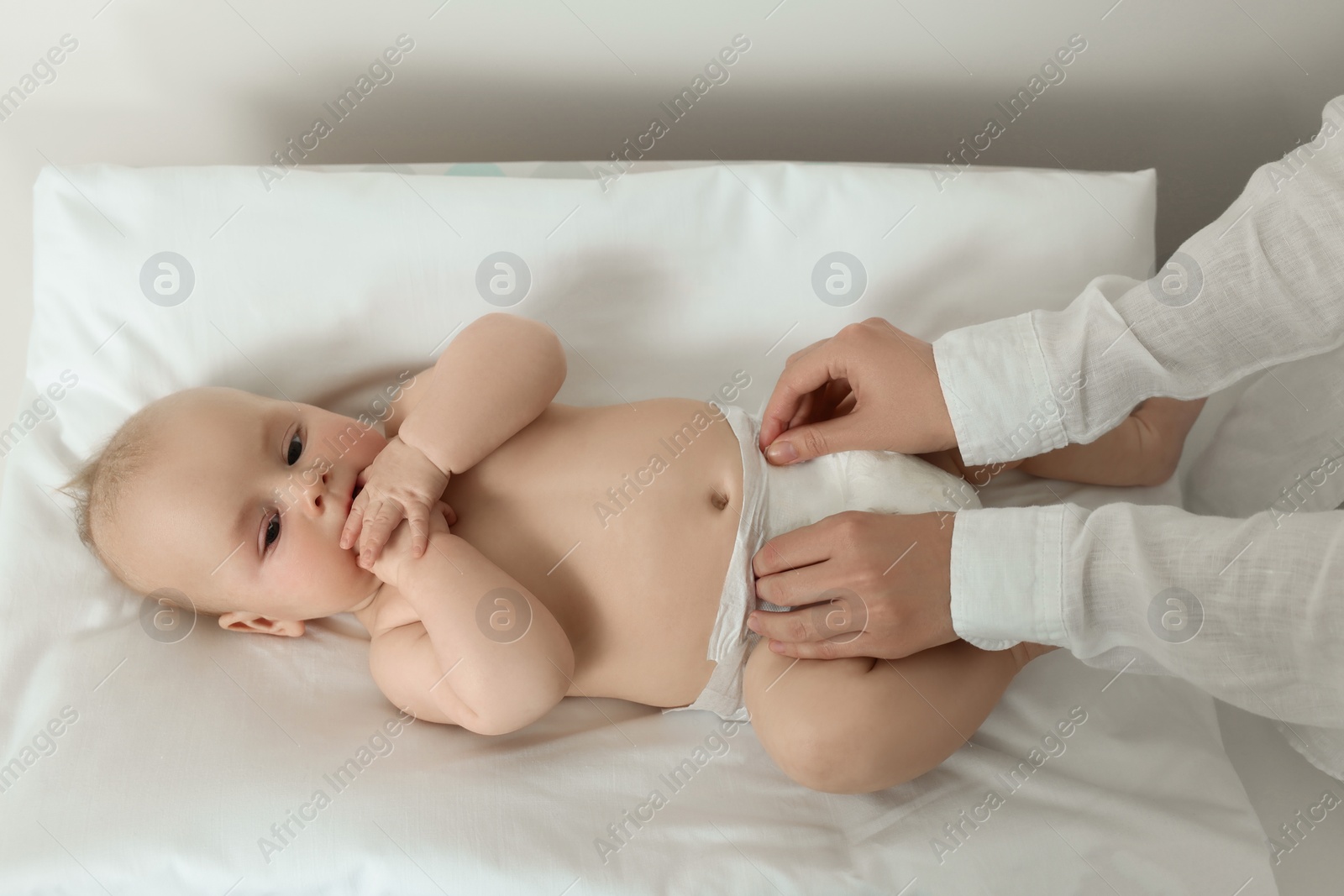 Photo of Mother changing her baby's diaper on table, closeup