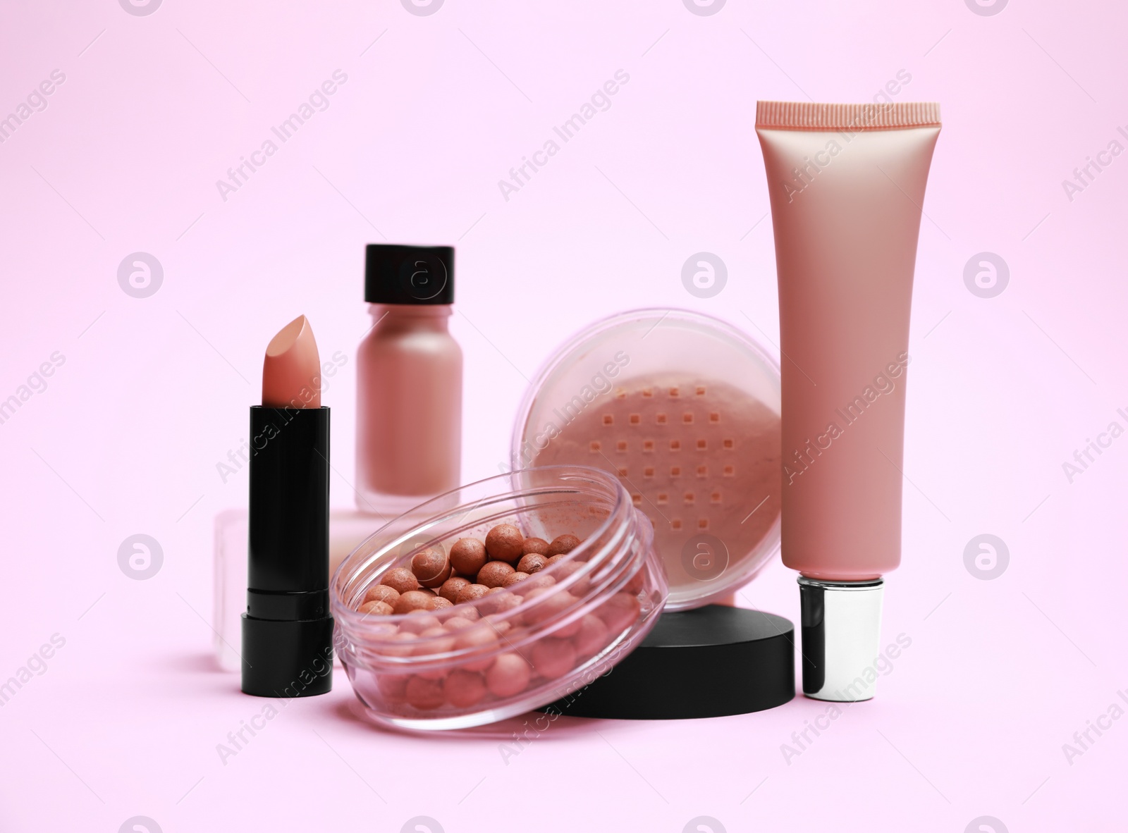 Photo of Face powders and other decorative cosmetic products on pink background