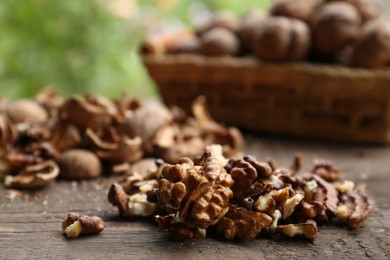 Photo of Pile of shelled walnuts on wooden table against blurred background, closeup. Space for text