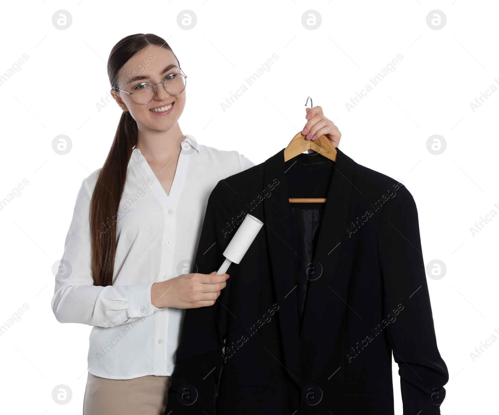 Photo of Young woman cleaning suit with lint roller on white background