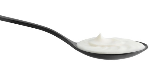 Photo of One black spoon with sour cream isolated on white