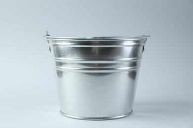 Photo of One shiny metal bucket on white background