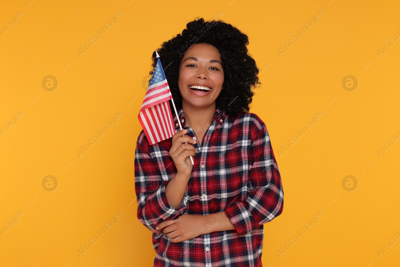 Photo of 4th of July - Independence Day of USA. Happy woman with American flag on yellow background