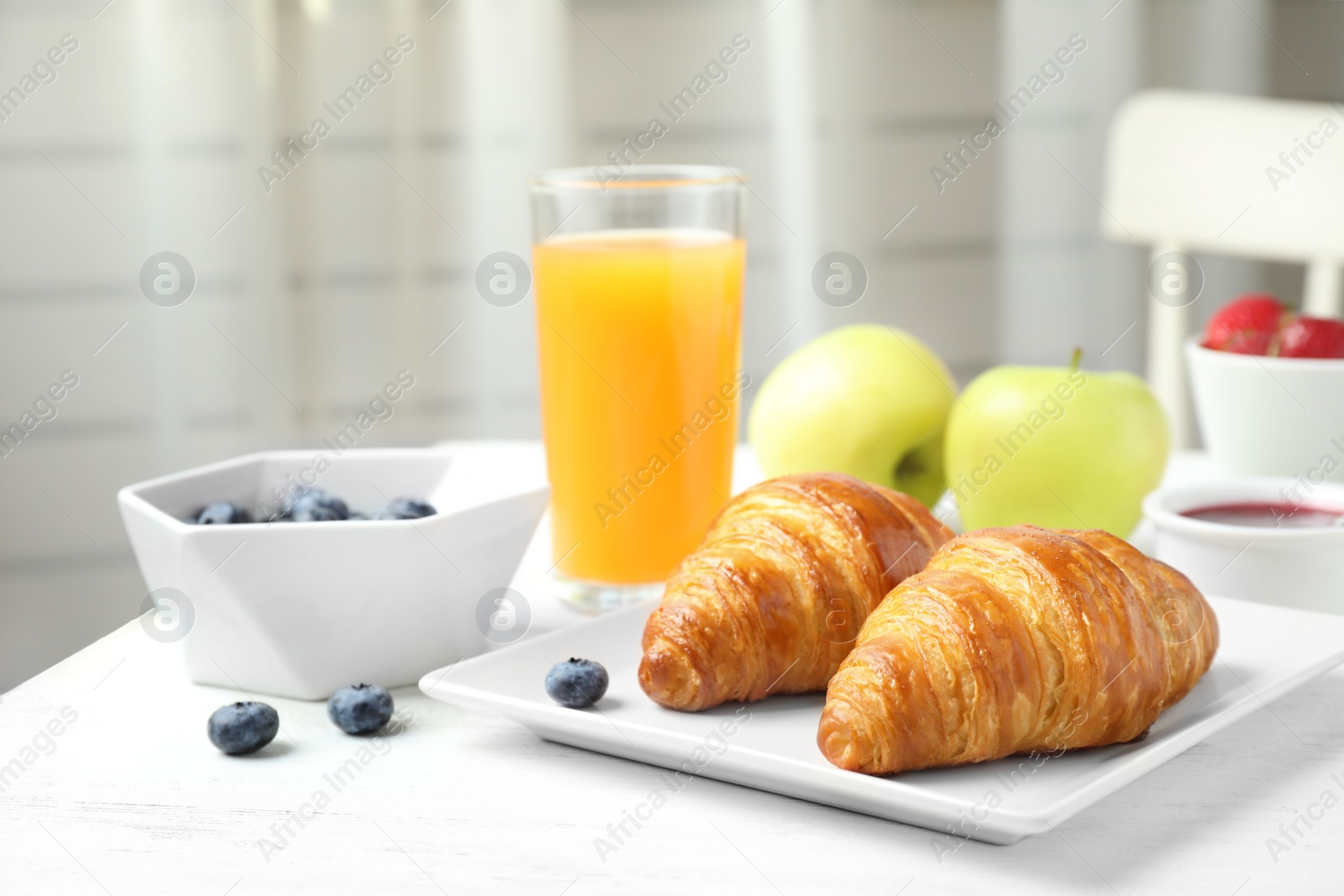 Photo of Tasty breakfast with croissants served on white wooden table