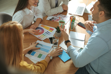 Photo of Team of professional designers working together at table in office