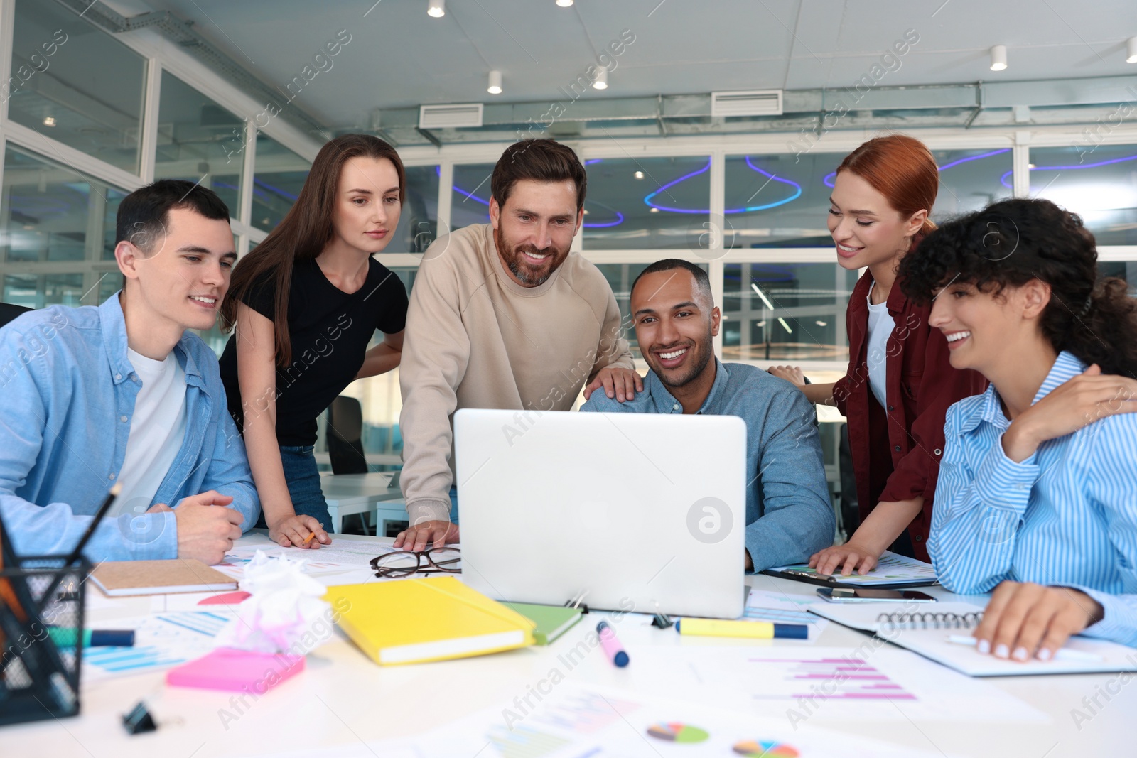 Photo of Team of employees working together at table in office. Startup project