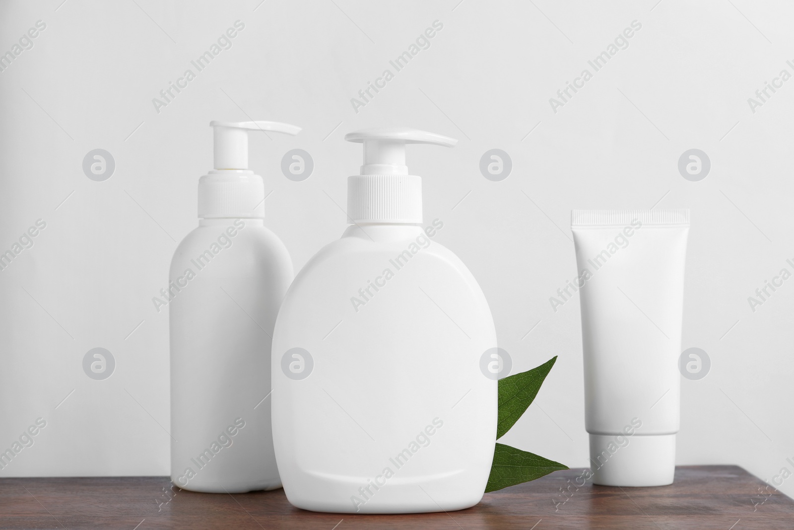 Photo of Bottles with different cosmetic products on wooden table