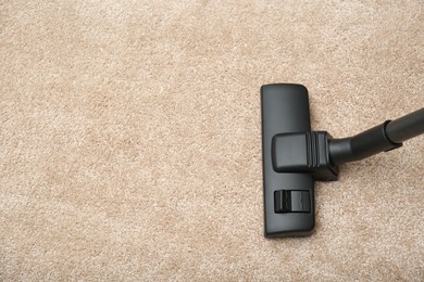 Photo of Removing dirt from carpet with vacuum cleaner indoors, top view. Space for text