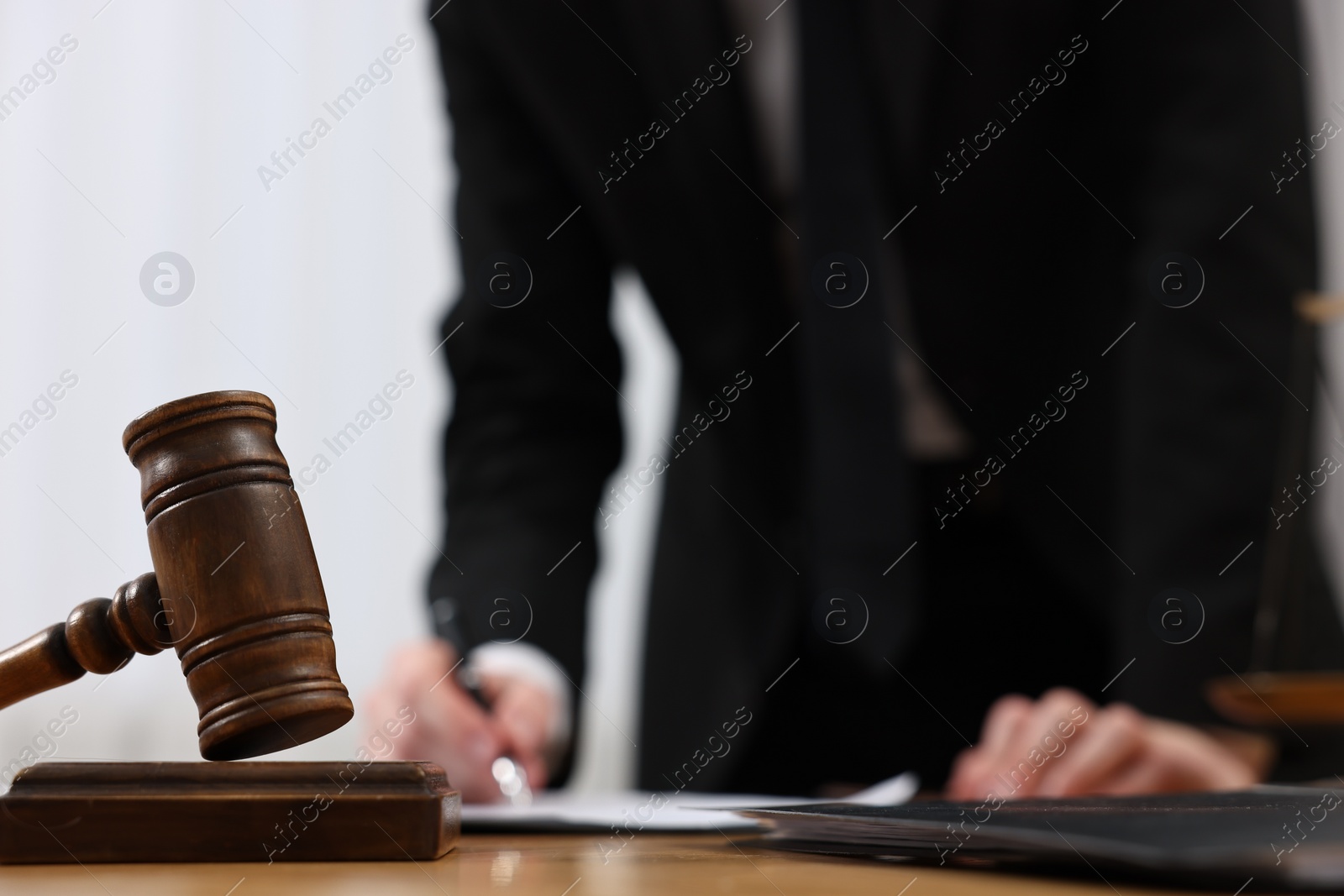 Photo of Lawyer working with document at table, focus on gavel