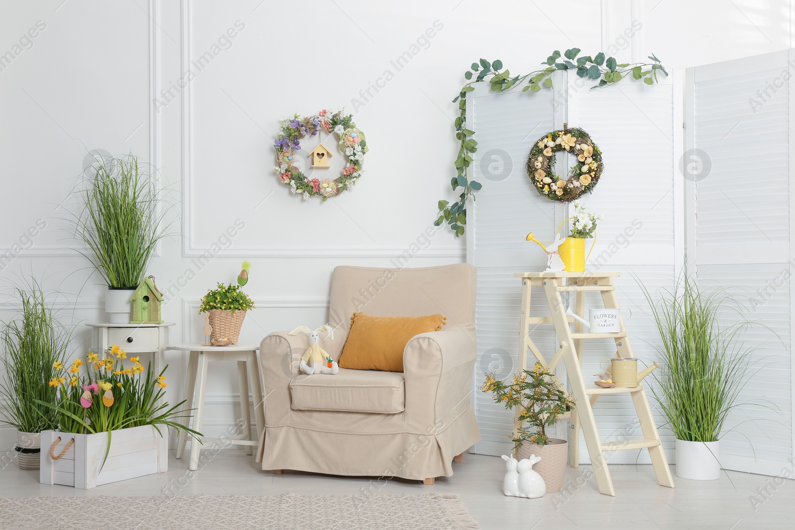 Photo of Elegant Easter photo zone with floral decor and armchair indoors