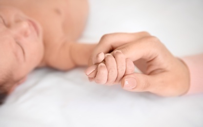 Mother holding little baby hand