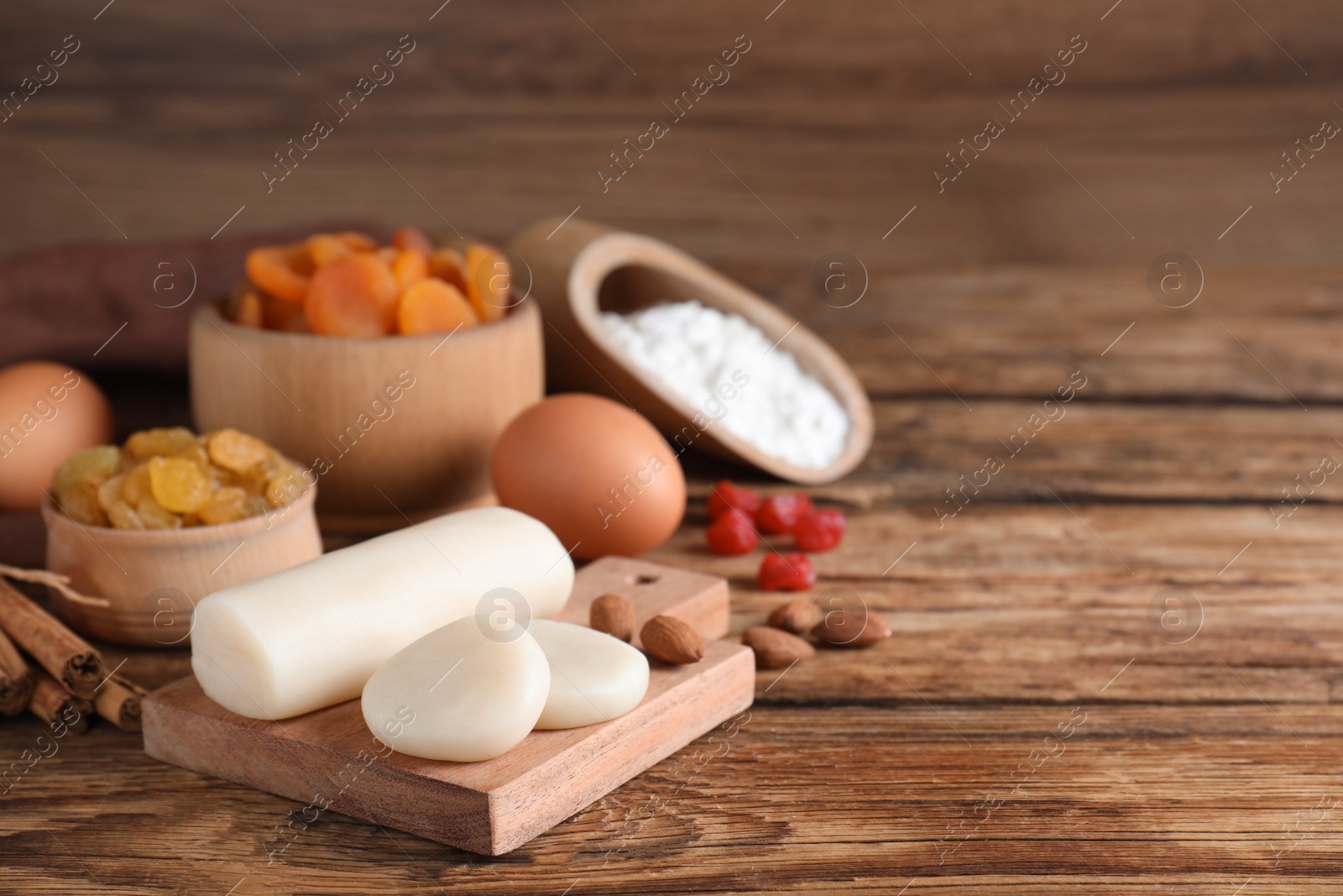 Photo of Marzipan and other ingredients for homemade Stollen on wooden table. Baking traditional German Christmas bread