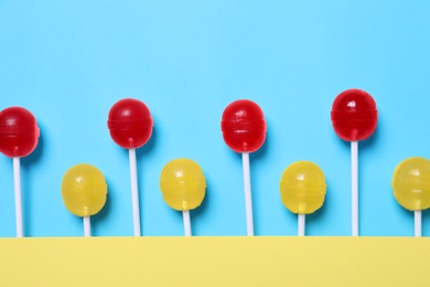 Photo of Sweet lollipops on light blue background, flat lay