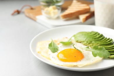 Photo of Tasty breakfast with fried egg and avocado on table, closeup