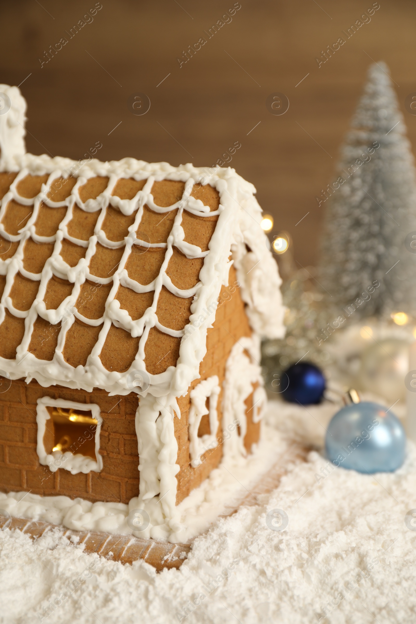 Photo of Beautiful gingerbread house decorated with icing on snow