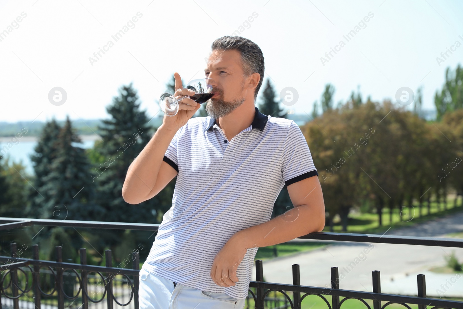 Photo of Man with glass of red wine outdoors