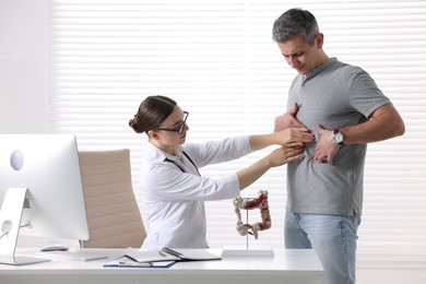 Photo of Gastroenterologist examining patient with stomach pain in clinic