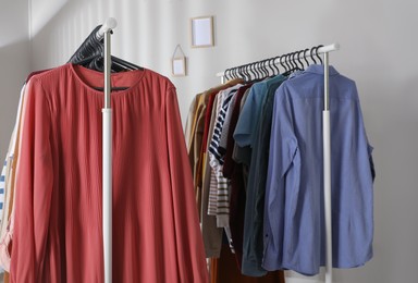 Photo of Racks with stylish clothes indoors. Fast fashion