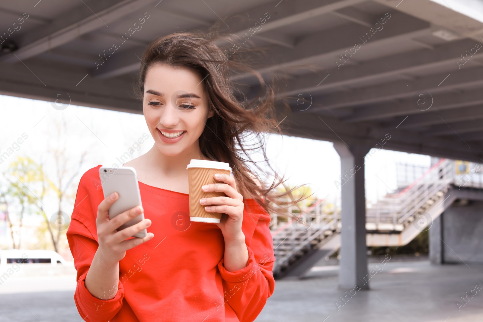 Photo of Young woman using mobile phone outdoors