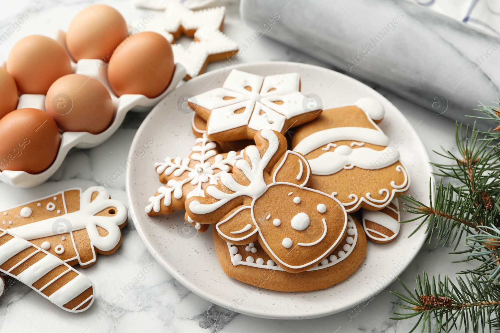 Photo of Delicious homemade Christmas cookies, eggs and fir tree on white marble table