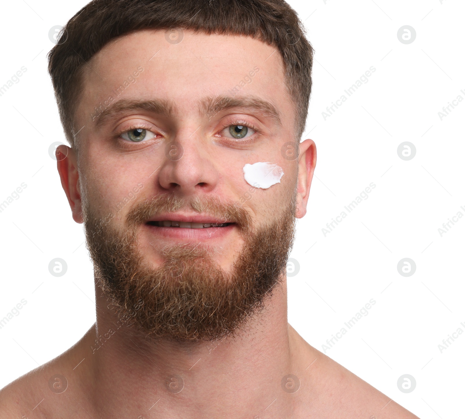 Photo of Handsome man with moisturizing cream on his face against white background