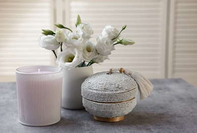 Scented candle, box and eustoma flowers on gray marble table