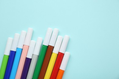 Photo of Different colorful markers on light blue background, flat lay. Space for text