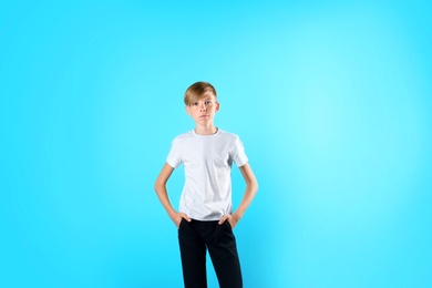 Photo of Portrait of young boy standing against color background