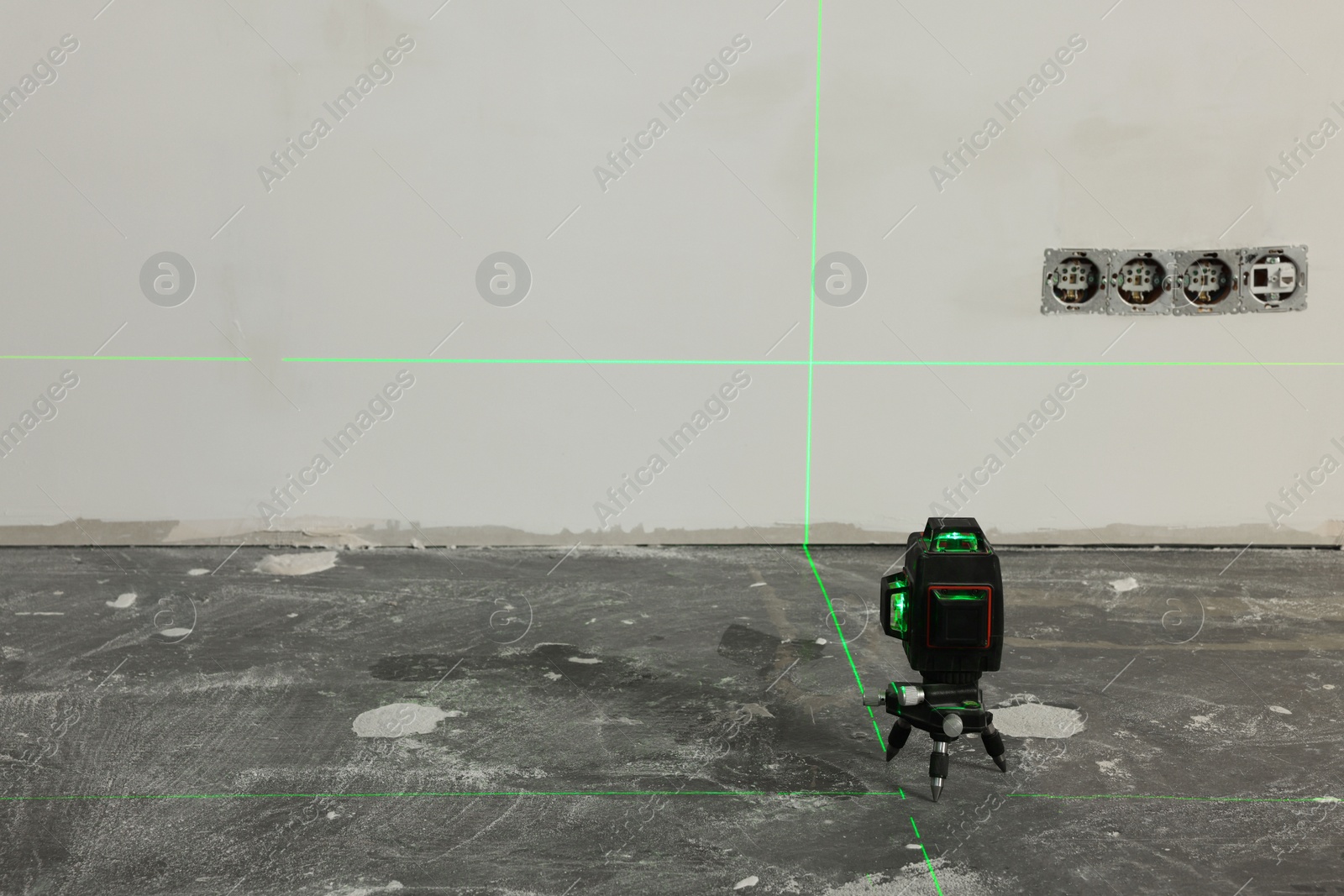 Photo of Laser level on floor near electrical sockets