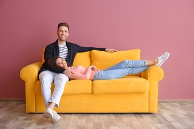 Photo of Happy young couple on sofa, indoors