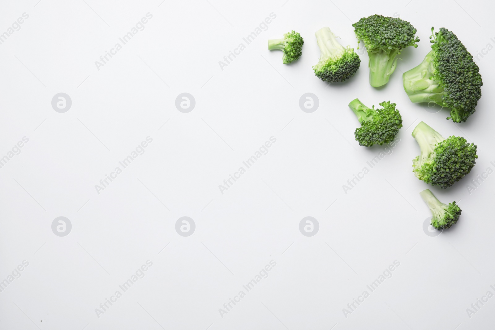 Flat lay composition with fresh green broccoli on light background. Space for text Photo of Flat lay composition with fresh green broccoli on light background. Space for text