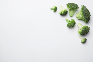 Photo of Flat lay composition with fresh green broccoli on light background. Space for text