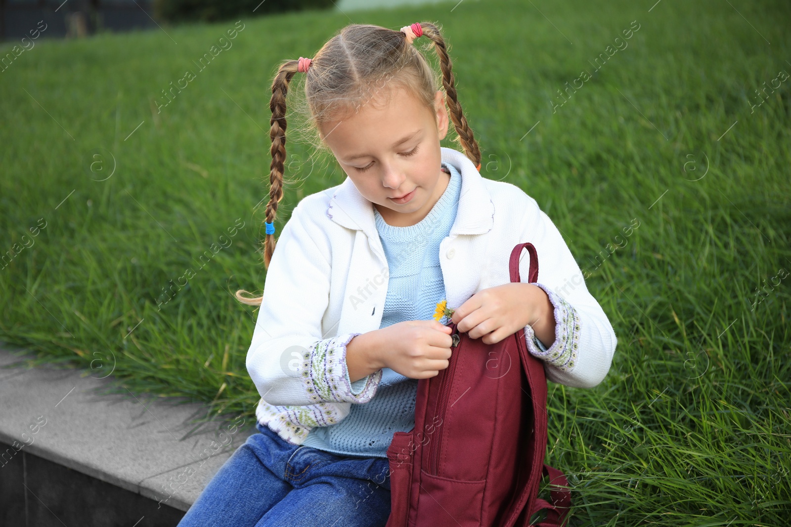 Photo of Cute little girl with backpack on city street